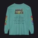A teal long-sleeve t-shirt with a humorous 'HOC Slots' gaming score printed on the back, featuring colorful dice graphics on the sleeves and a detailed text list of gaming achievements in the center.