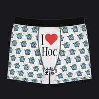White boxer briefs with a black waistband, featuring a repeating pattern of blue shopping carts with green cash and a central graphic that reads 'I ♥ Hoc' with 'House of Cards' branding near the hem.