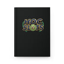 A black hardcover notebook featuring a 'HOC SLOTS 10' logo printed on the front cover in gold, blue, and green, set against a plain white background.