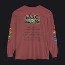 A long-sleeve t-shirt in a dusty rose or mauve color, featuring a 'HOC SLOTS 10' graphic on the back with various gaming statistics printed in black text, and colorful hexagonal patches on both sleeves.