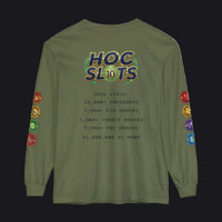 An olive green long-sleeve t-shirt with a humorous 'HOC SLOTS 10' meme graphic printed on the back, featuring mock gaming statistics and colorful hexagonal icons on both sleeves.
