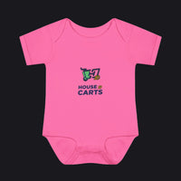 A bright pink short-sleeve baby bodysuit with a colorful graphic on the chest showing a shopping cart and the text 'HOUSE OF CARTS' in navy and green, displayed on a clean white background.