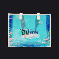 A clear vinyl beach tote bag with white handles, featuring a holographic blue and purple border and a printed 'HOUSE CARTS' logo on the front, set against a plain white background.
