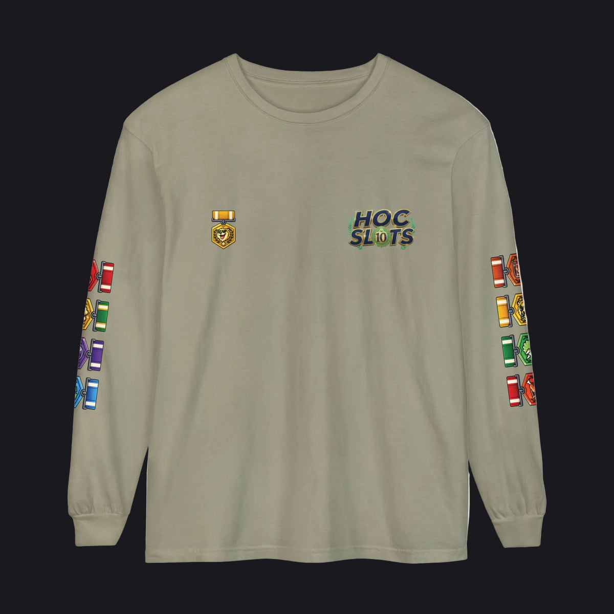 A long-sleeve crewneck t-shirt in khaki beige, featuring a 'HOC SLOTS' graphic on the left chest, a small gold emblem on the right chest, and colorful military-style ribbons printed down both sleeves.
