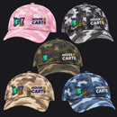 Five camouflage baseball caps arranged on a light gray background, each with embroidered 'HOUSE 10 CARTS' text and a green-and-yellow cart graphic. The caps are shown in pink, black/gray, woodland green, tan, and blue camo styles.