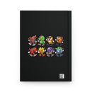 A black hardcover notebook featuring a colorful graphic of eight cartoonish robot and creature characters arranged in two rows on the front cover, with a small QR code in the bottom right corner.