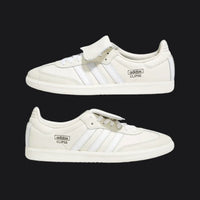 Pair of white Adidas Clipse sneakers on a black background